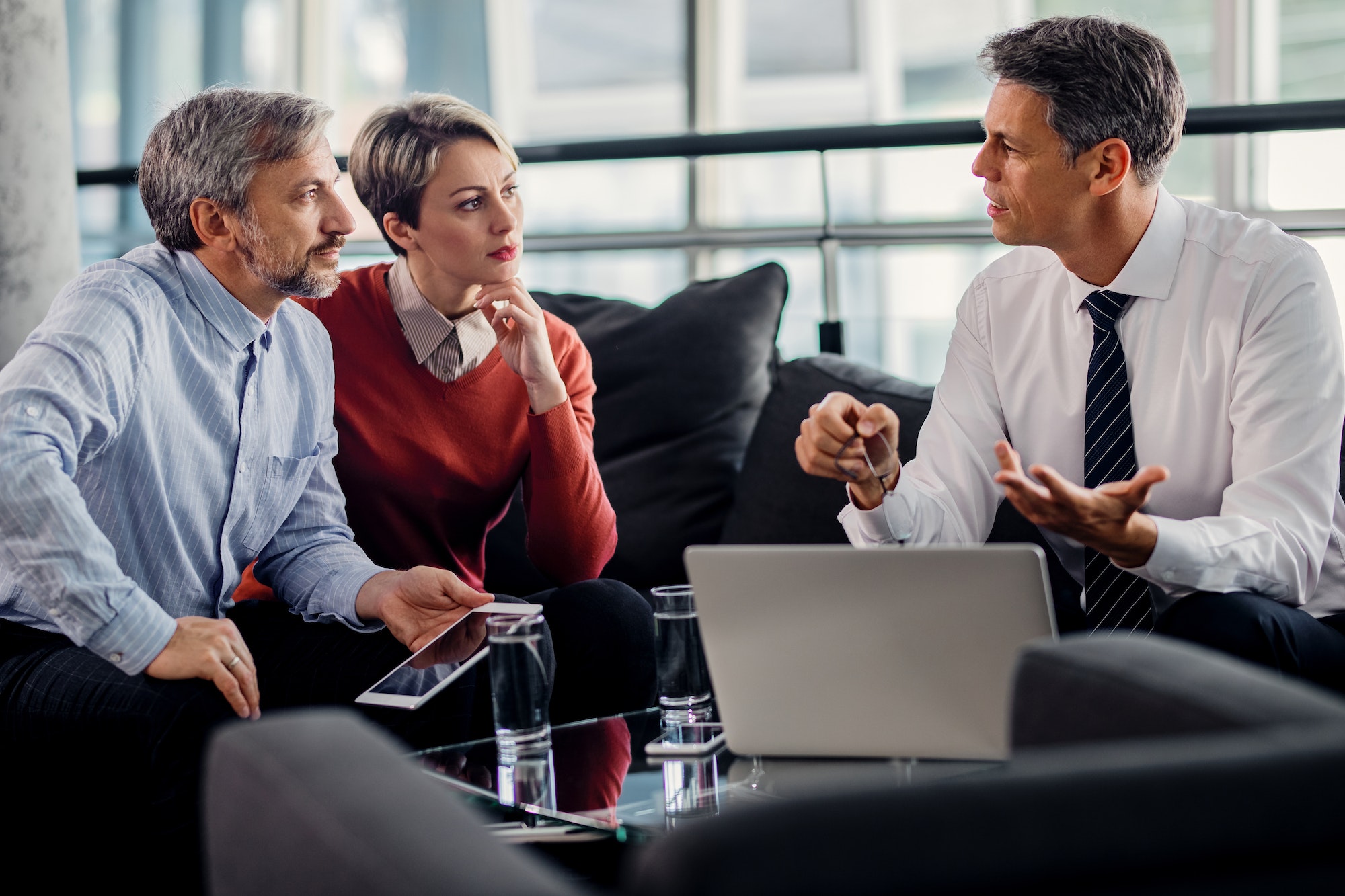 Insurance agent talking to mid adult couple on a meeting in the office.